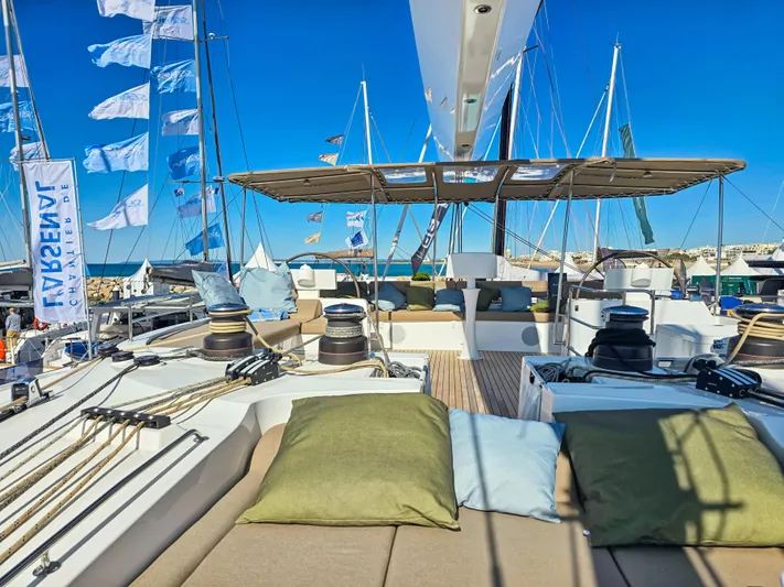 Firefly Yacht Photos Pics Luxurious Lagoon 620 NEO yacht deck with cushions, sails, and clear blue sky.