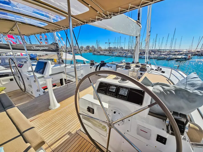 Firefly Yacht Photos Pics Luxurious Lagoon 620 NEO 2012 yacht interior with helm, marina view, and clear blue sky.