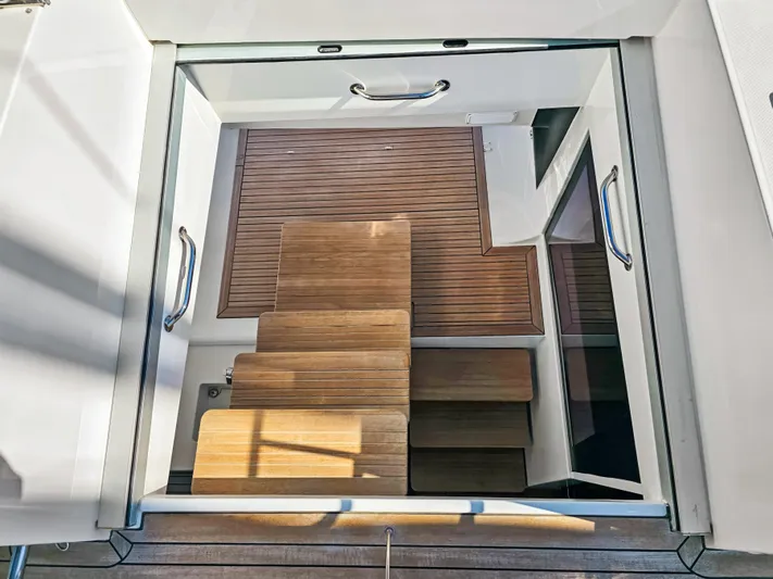 Firefly Yacht Photos Pics Staircase on Lagoon 620 NEO yacht, 2012 model, with wooden steps and sleek design.