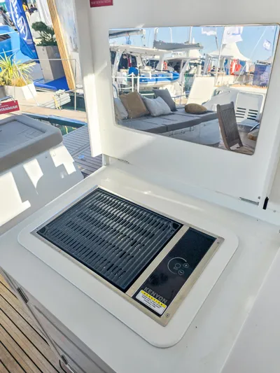 Firefly Yacht Photos Pics Outdoor grill on Lagoon 620 NEO yacht, 2012 model, with seating area in background.