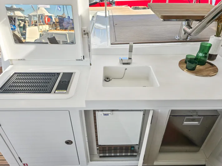 Firefly Yacht Photos Pics Outdoor kitchen on 2012 Lagoon 620 NEO yacht with sink, grill, and storage.