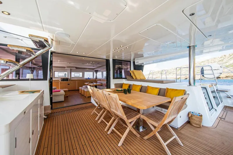 Firefly Yacht Photos Pics Luxurious Lagoon 620 NEO 2012 yacht interior with wooden deck and elegant dining area.