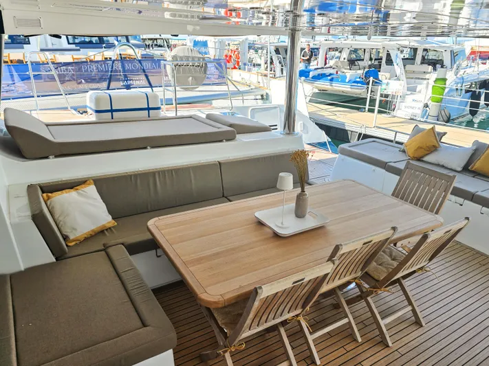 Firefly Yacht Photos Pics Spacious deck of 2012 Lagoon 620 NEO yacht with elegant seating and dining area.