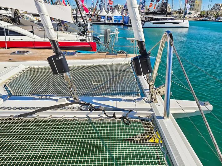 Firefly Yacht Photos Pics Catamaran Lagoon 620 NEO 2012 at marina, showcasing netting and rigging details.