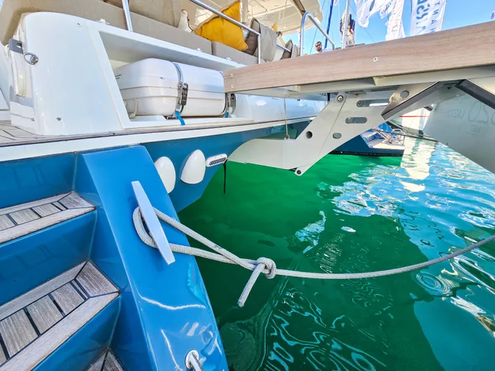 Firefly Yacht Photos Pics Lagoon 620 NEO 2012 yacht with blue hull, docked, showing steps and mooring line.