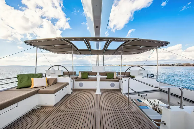Firefly Yacht Photos Pics Luxurious Lagoon 620 NEO 2012 yacht deck with seating, ocean view, and blue sky.