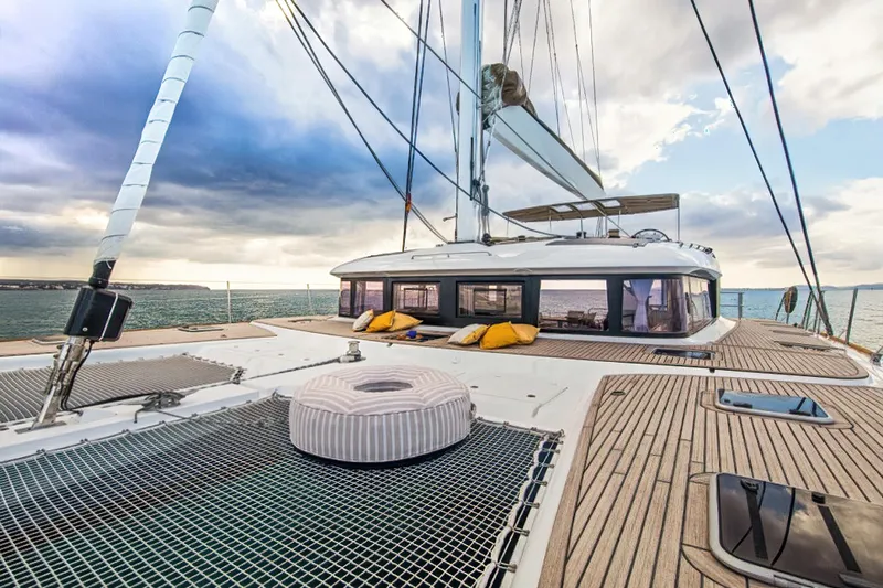 Firefly Yacht Photos Pics Lagoon 620 NEO 2012 catamaran sailing on open sea under cloudy sky.