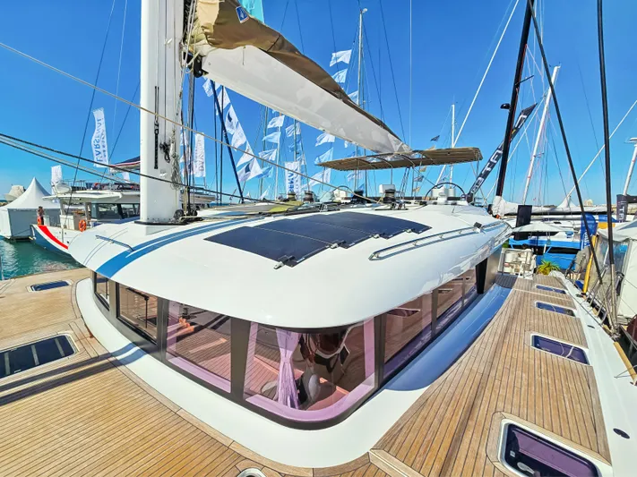 Firefly Yacht Photos Pics Lagoon 620 NEO 2012 yacht with sleek design and spacious deck at a marina.