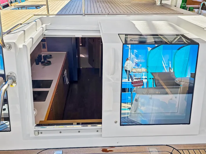 Firefly Yacht Photos Pics Interior view of 2012 Lagoon 620 NEO yacht, showcasing kitchen and deck access.