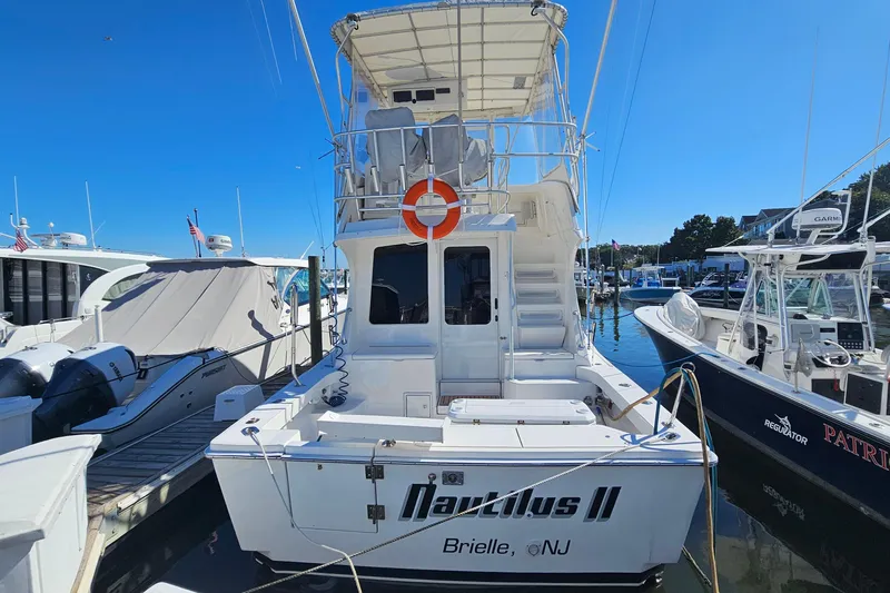  Yacht Photos Pics 2004 Luhrs 34 Convertible boat docked at marina, featuring upper deck and life preserver.