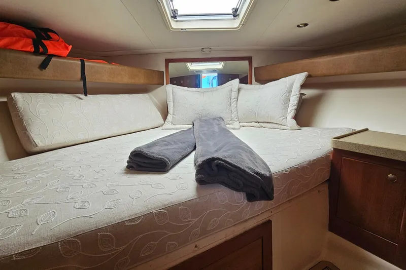  Yacht Photos Pics Cozy cabin interior of 2004 Luhrs 34 Convertible with bed and pillows.