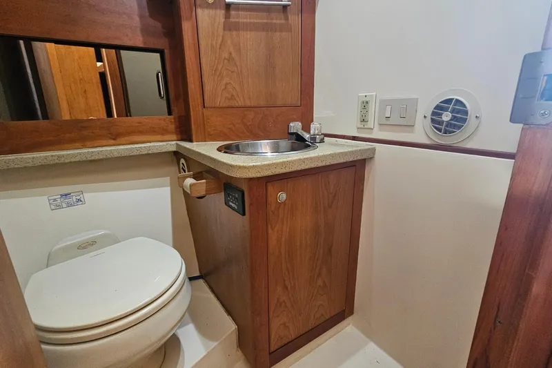 Yacht Photos Pics 2004 Luhrs 34 Convertible yacht bathroom with wooden cabinetry and compact fixtures.