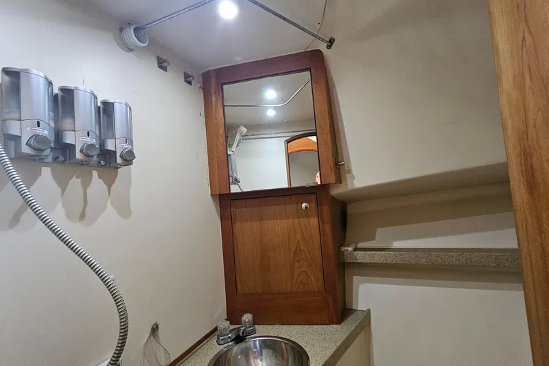  Yacht Photos Pics 2004 Luhrs 34 Convertible bathroom with dispensers, mirror, and sink.