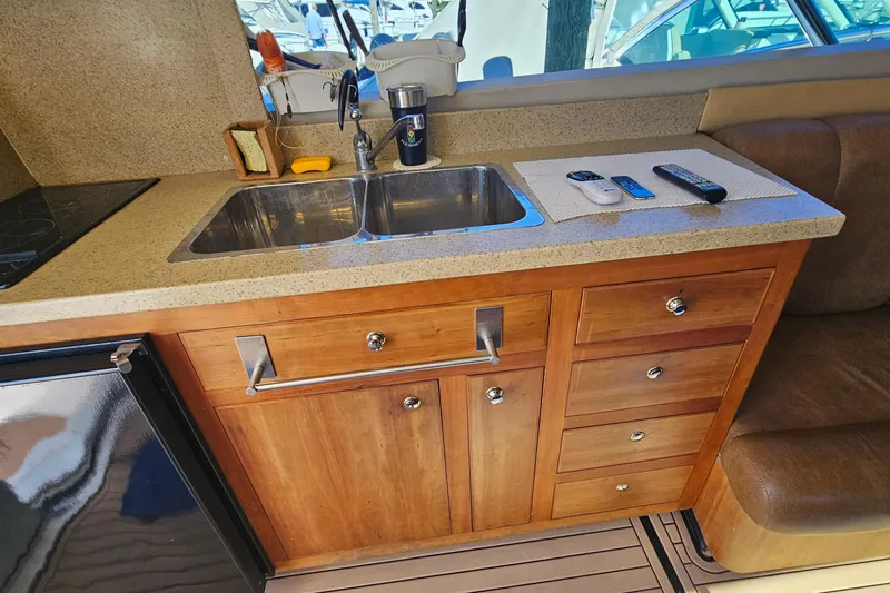  Yacht Photos Pics 2004 Luhrs 34 Convertible yacht kitchen with sink, wooden cabinets, and countertop accessories.
