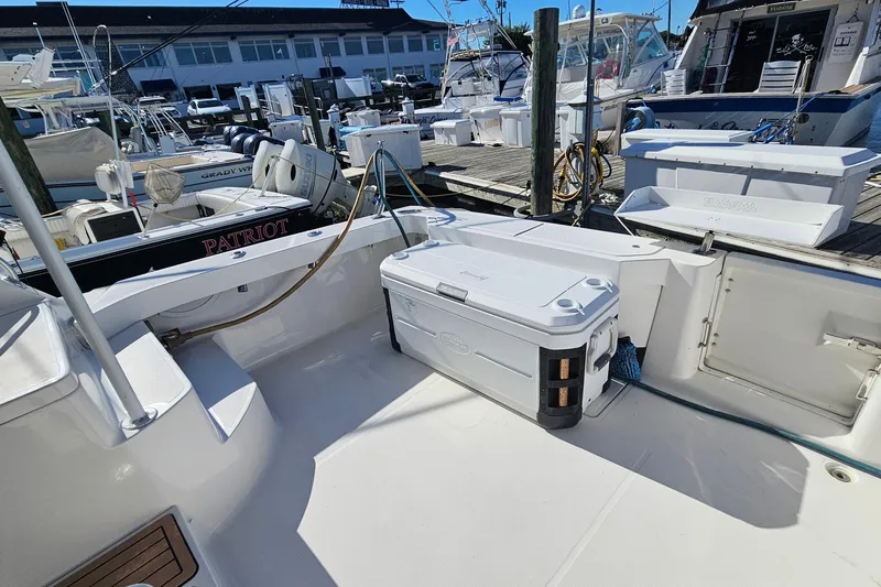  Yacht Photos Pics 2004 Luhrs 34 Convertible boat deck with cooler and docked vessels in marina.