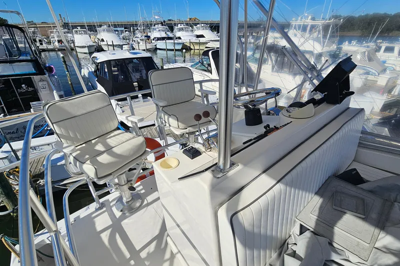  Yacht Photos Pics 2004 Luhrs 34 Convertible boat interior with helm chairs and marina view.