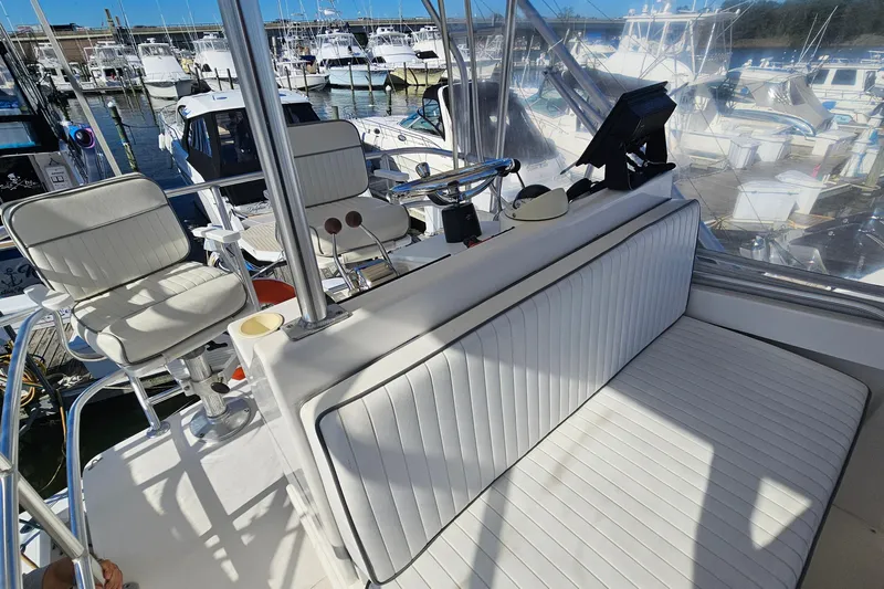  Yacht Photos Pics 2004 Luhrs 34 Convertible boat interior with white seating and control panel at marina.