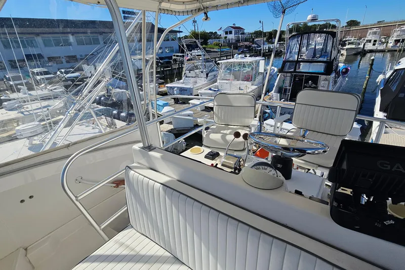  Yacht Photos Pics 2004 Luhrs 34 Convertible boat interior at marina, featuring helm and seating area.