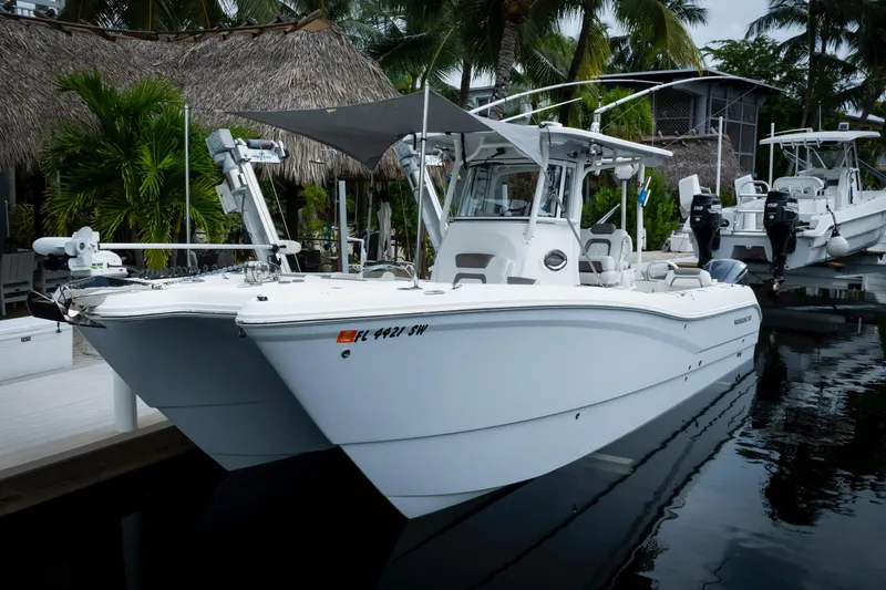  Yacht Photos Pics 2021 World Cat 295 CC boat docked near tropical foliage.