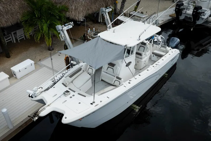  Yacht Photos Pics 2021 World Cat 295 CC boat docked, featuring a sunshade and spacious seating.
