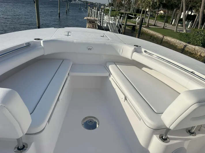  Yacht Photos Pics 2024 Southport 30 FE boat with white cushioned seating, docked by the waterfront.