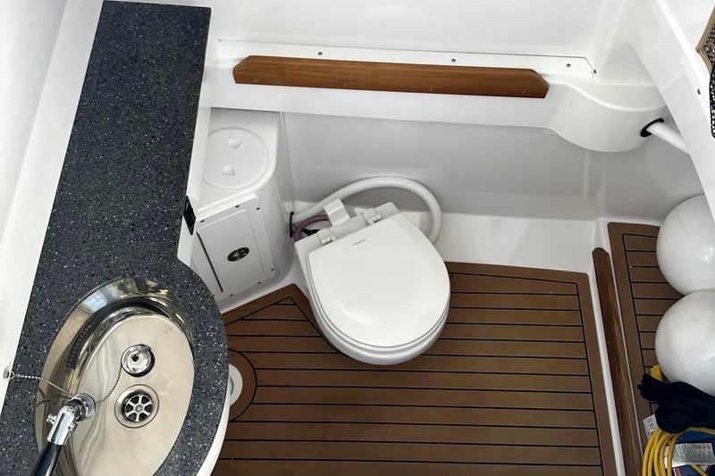  Yacht Photos Pics 2024 Southport 30 FE boat bathroom with sink, toilet, and wooden flooring.