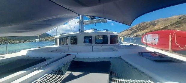 Katarina Yacht Photos Pics Lagoon 440 catamaran, 2010 model, anchored in a scenic coastal bay under clear blue skies.