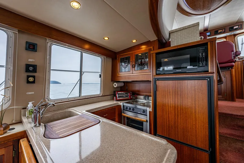 Big Red Yacht Photos Pics Luxurious 2007 American Tug 41 interior kitchen with wood cabinetry and ocean view.