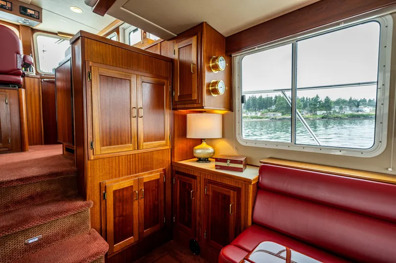 Big Red Yacht Photos Pics Interior of 2007 American Tug 41 with wood cabinetry and red seating by a window.