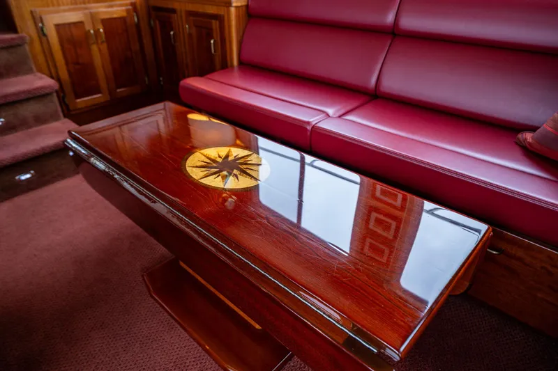 Big Red Yacht Photos Pics Luxurious interior of 2007 American Tug 41 with polished wood table and red leather seating.
