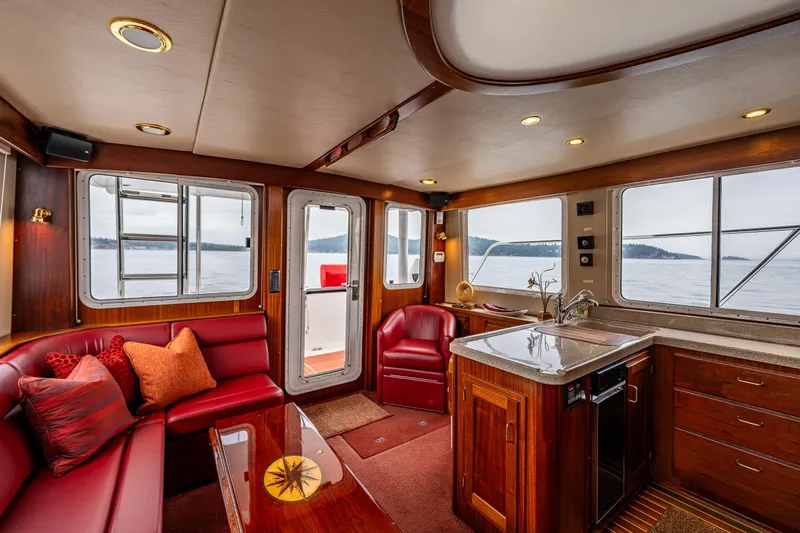 Big Red Yacht Photos Pics Luxurious interior of a 2007 American Tug 41 with red seating and wooden cabinetry.