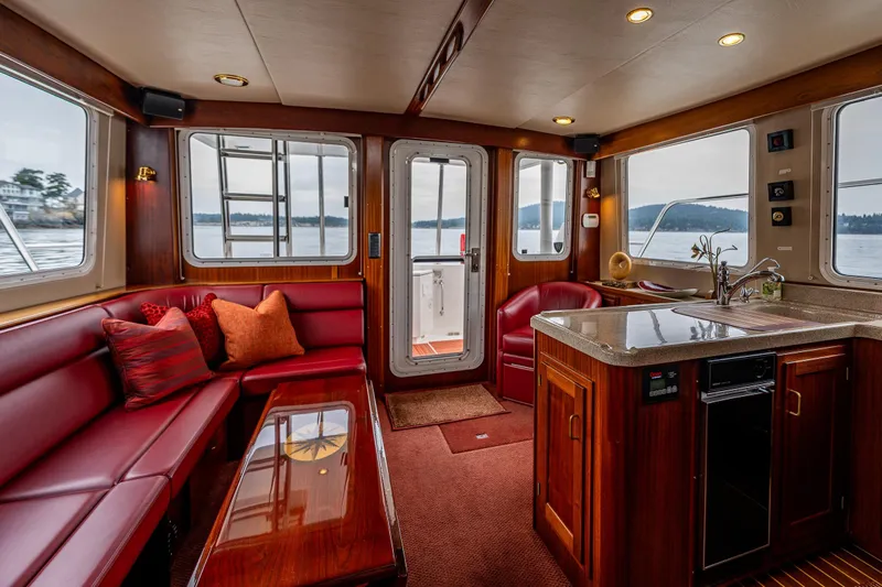 Big Red Yacht Photos Pics Luxurious interior of 2007 American Tug 41 with red seating, wood accents, and scenic water views.