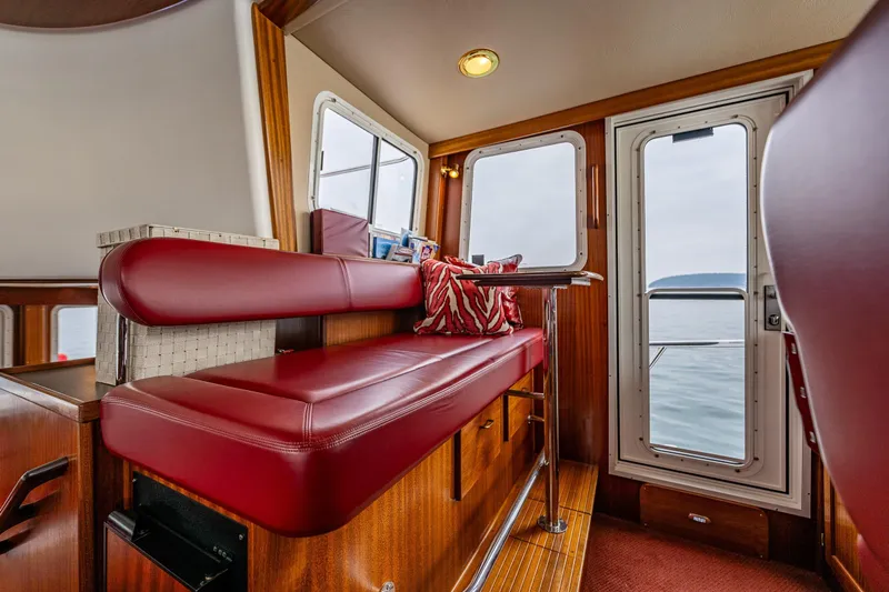 Big Red Yacht Photos Pics Interior of 2007 American Tug 41 with red seating and ocean view through windows.