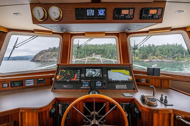 Big Red Yacht Photos Pics American Tug 41 helm, 2007 model, featuring navigation instruments and scenic waterway view.