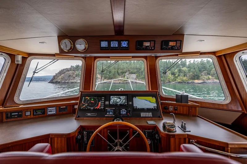Big Red Yacht Photos Pics Pilothouse of 2007 American Tug 41, featuring navigation instruments and scenic waterway view.