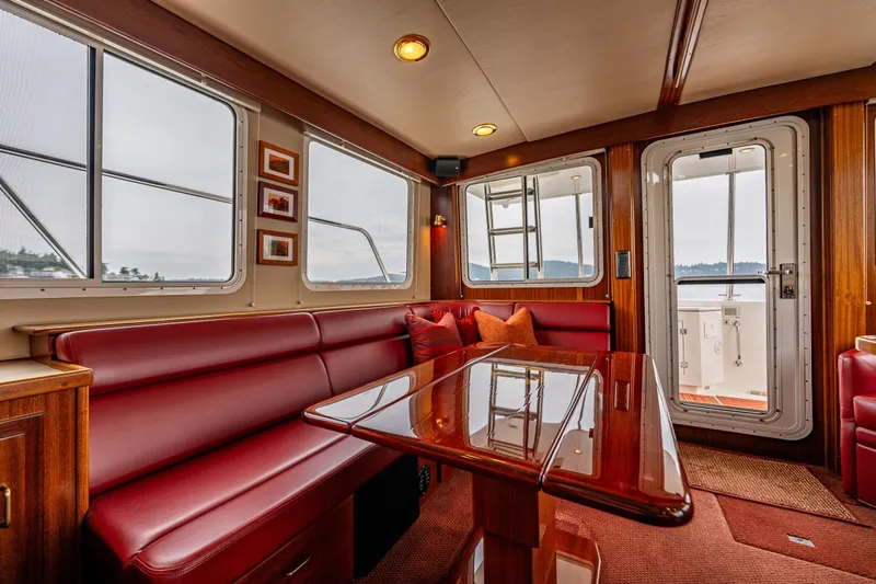 Big Red Yacht Photos Pics Luxurious interior of 2007 American Tug 41 with red seating and polished wood table.