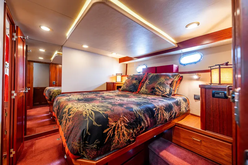 Big Red Yacht Photos Pics Luxurious bedroom interior of 2007 American Tug 41 yacht with elegant bedding and warm lighting.
