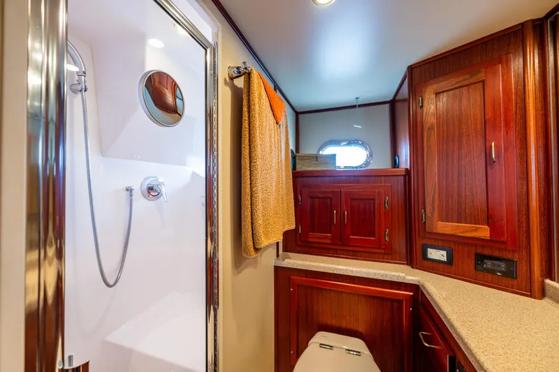Big Red Yacht Photos Pics Luxurious bathroom in 2007 American Tug 41 with wood cabinetry and modern shower.