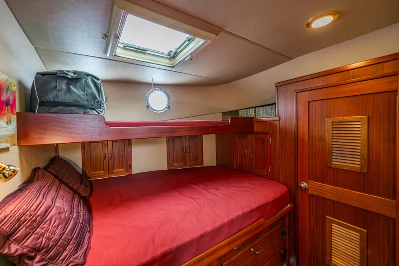 Big Red Yacht Photos Pics Cozy cabin interior of 2007 American Tug 41 with wooden furnishings and red bedding.