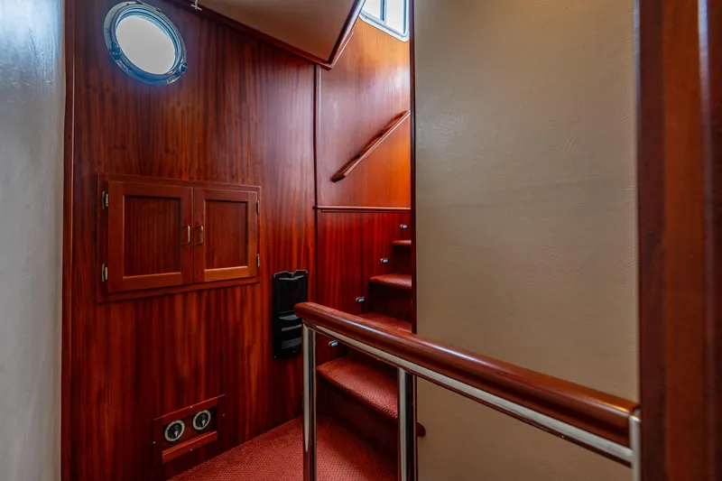 Big Red Yacht Photos Pics Interior of 2007 American Tug 41 with wooden stairs and porthole window.