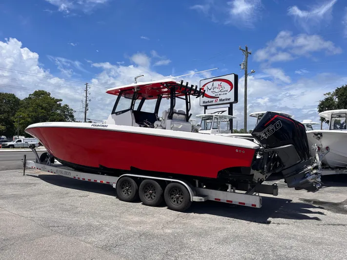  Yacht Photos Pics 2023 Fountain 38 Tournament Edition boat with red hull on a trailer, parked outdoors.