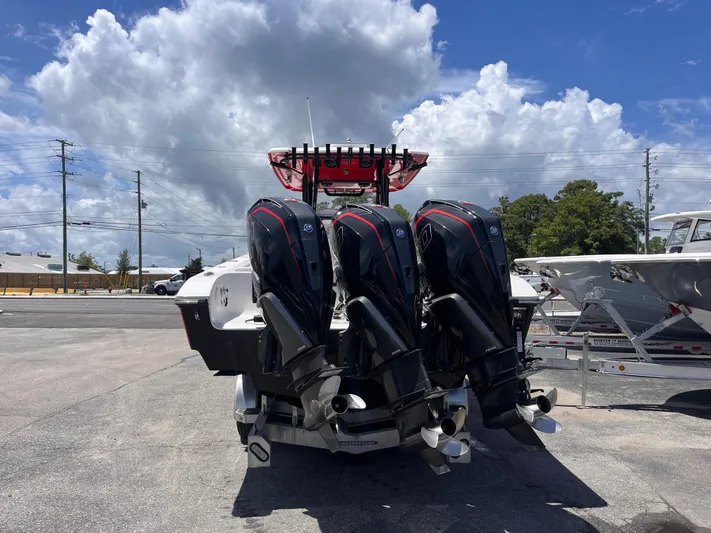 Yacht Photos Pics 2023 Fountain 38 Tournament Edition boat with triple outboard engines, parked under a cloudy sky.
