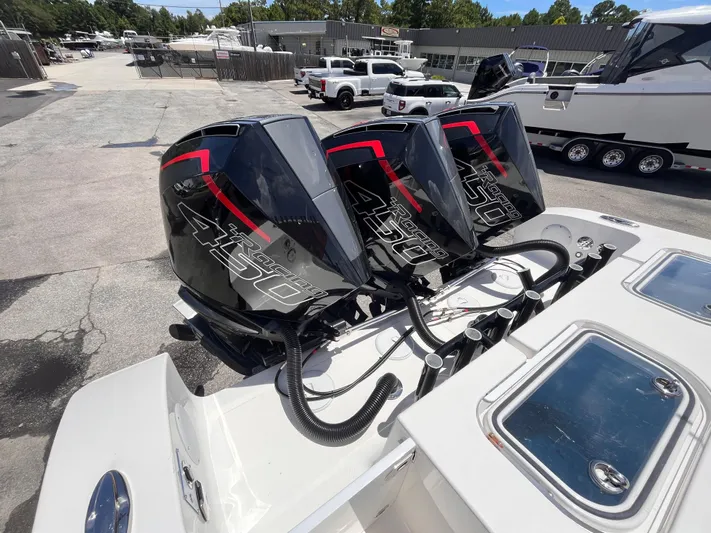  Yacht Photos Pics Triple outboard engines on a 2023 Fountain 38 Tournament Edition boat, parked in a marina.