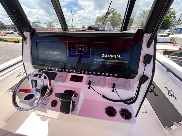  Yacht Photos Pics 2023 Fountain 38 Tournament Edition boat dashboard with Garmin navigation system and steering wheel.
