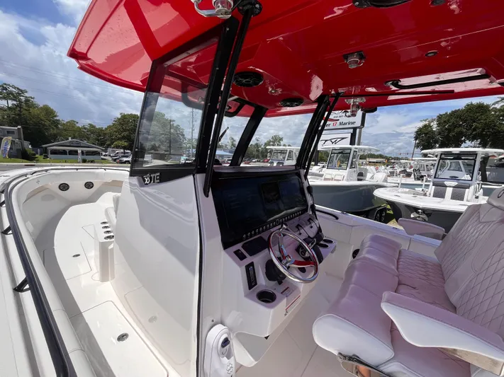  Yacht Photos Pics 2023 Fountain 38 Tournament Edition boat interior with red canopy and modern dashboard.