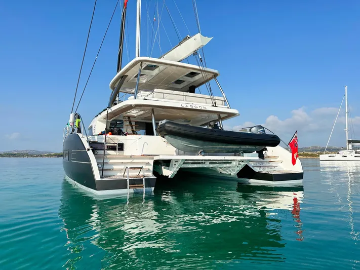 Big Picture Yacht Photos Pics 2024 Lagoon SIXTY 5 yacht on calm water, rear view with tender boat.