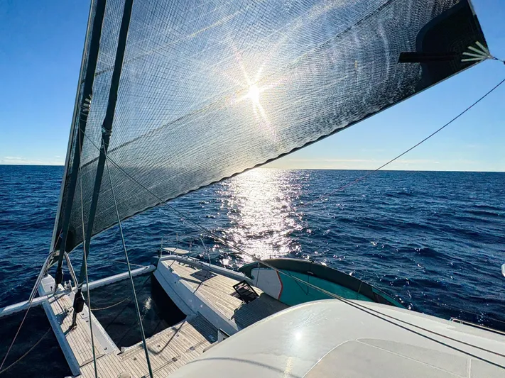 Big Picture Yacht Photos Pics 2024 Lagoon SIXTY 5 sailing on open sea under bright sun.