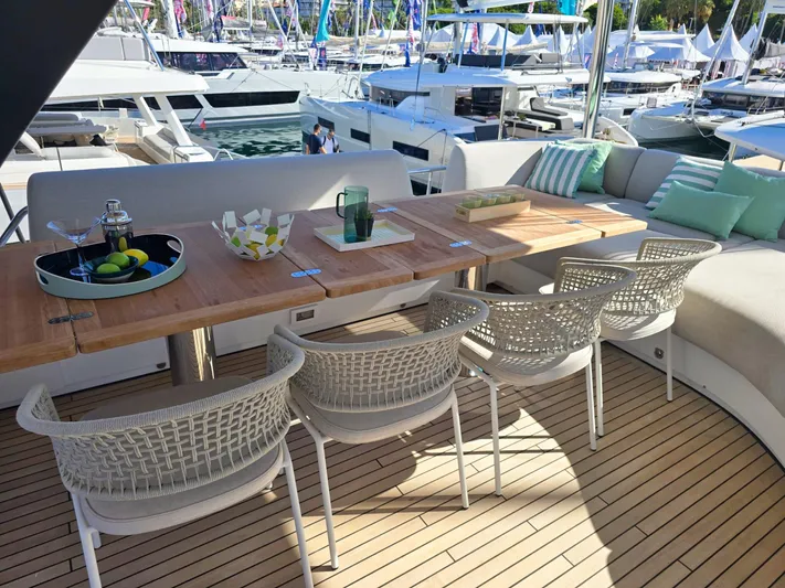 Big Picture Yacht Photos Pics Luxurious 2024 Lagoon SIXTY 5 yacht deck with elegant seating and dining area.