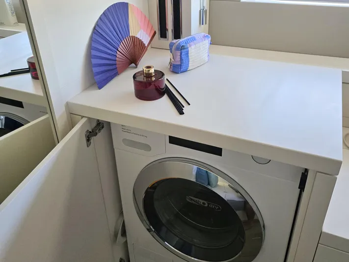 Big Picture Yacht Photos Pics Laundry area on Lagoon SIXTY 5 yacht, featuring a washing machine and decorative items.