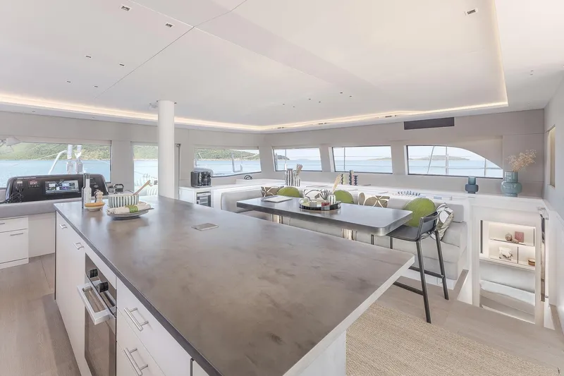 Big Picture Yacht Photos Pics Luxurious interior of 2024 Lagoon SIXTY 5 yacht with modern kitchen and dining area.